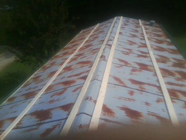 Rusted metal roof panels with new wood purlins before replacement — Storm Damage Roof Repair in Kimball by Roofing Brothers