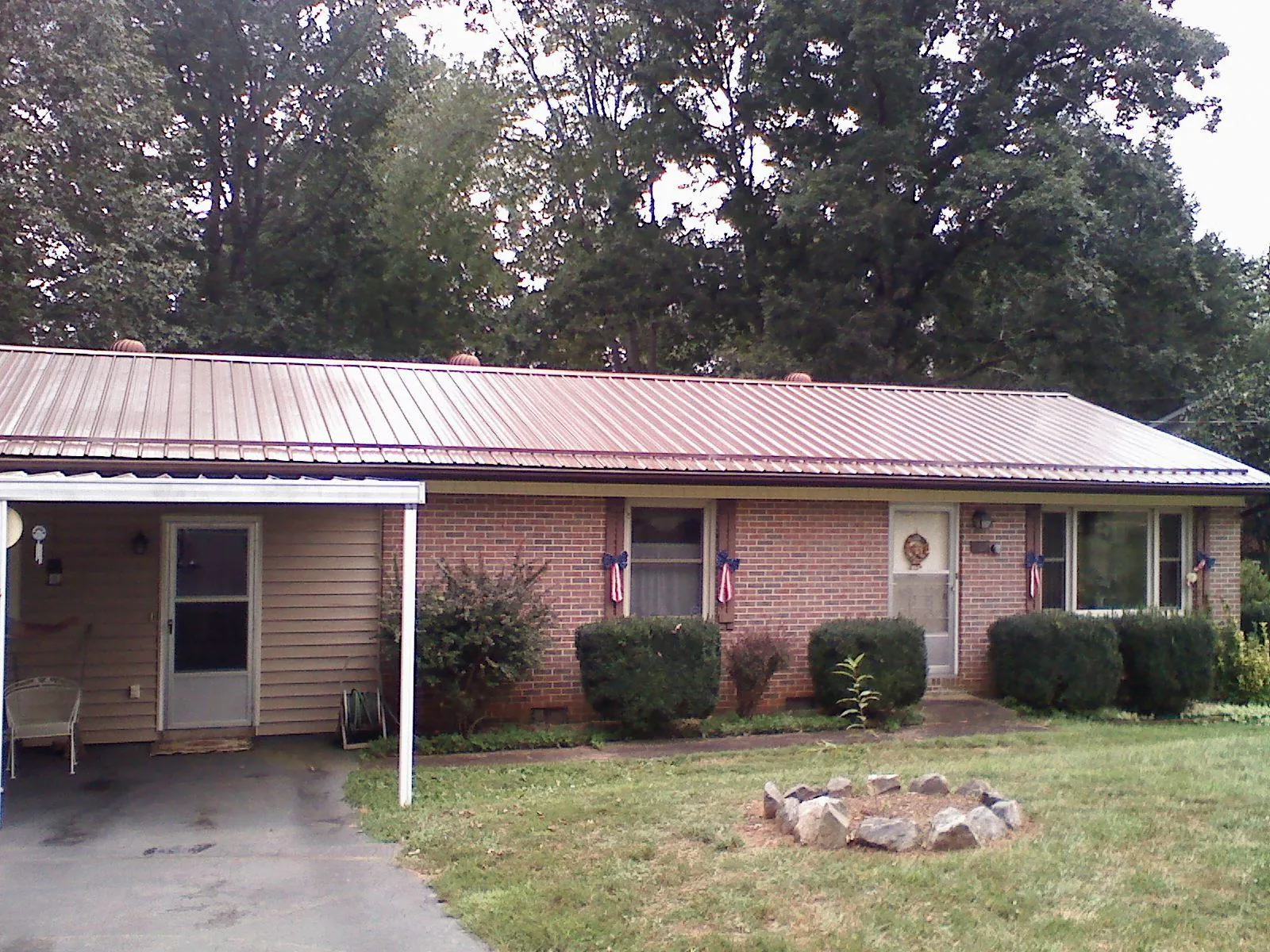 Bronze metal roof and carport on a brick ranch home — Roof Repair work by our crew in Kimball