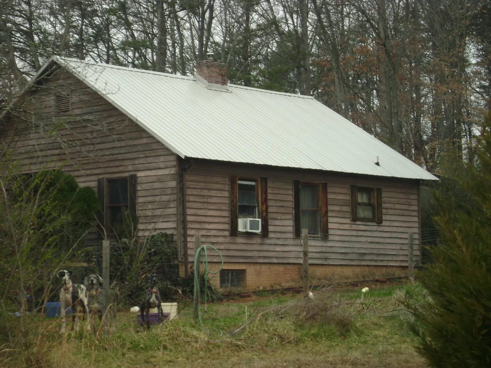 White metal roof on an old wood sided farmhouse, from a Metal Roof Installation job in Kimball